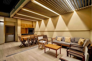 A modern interior with a dining area, sofa, and wooden furniture.