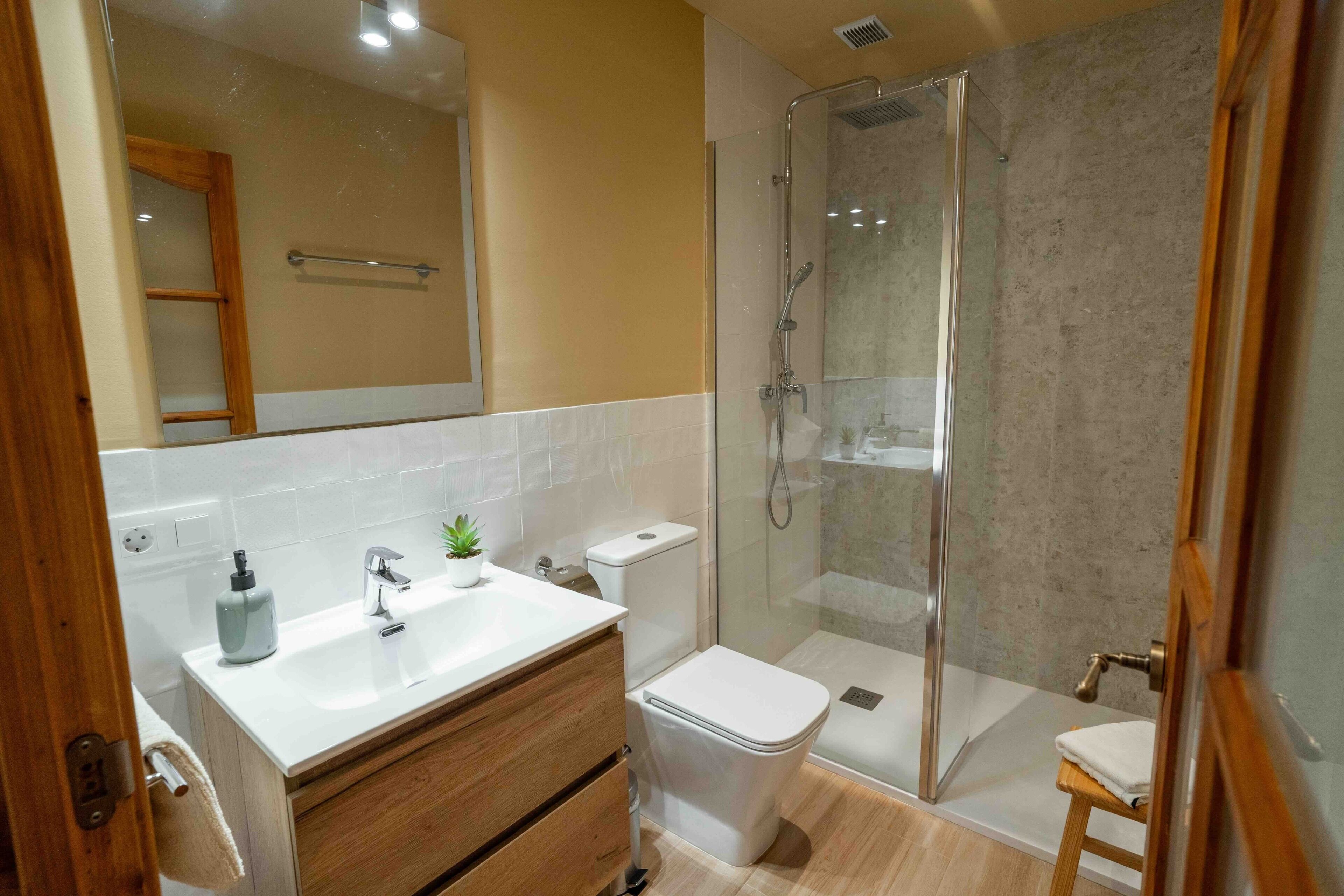 A modern bathroom with a shower, toilet, and sink.