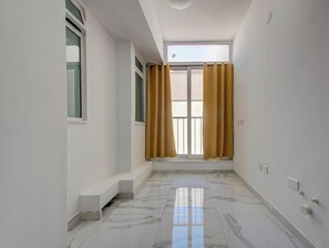 A corridor with a tiled floor, a window with yellow curtains, and a skylight. - Prime Swieqi 6BR w/ Private Pool & Sundeck (Swieqi)