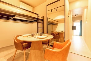 A dining area with a round table, chairs, and a large mirror. - DeLCCS Ryogoku (Tokyo)