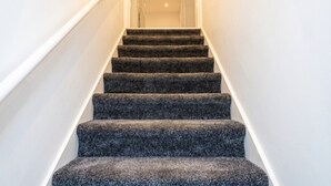 A staircase with carpeted steps leading to a door at the top. - Newly refurbished London base with Jubilee line on your doorstep (Greater London)