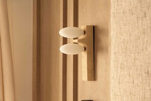 Eine Wandleuchte mit zwei ovalen Lampen an einer Holzwand.
