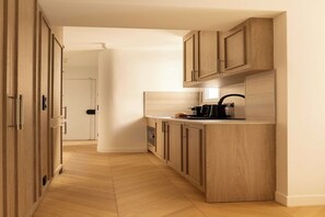 Eine moderne Küche mit Holzausstattung, einer Arbeitsplatte und einer Kaffeemaschine.
