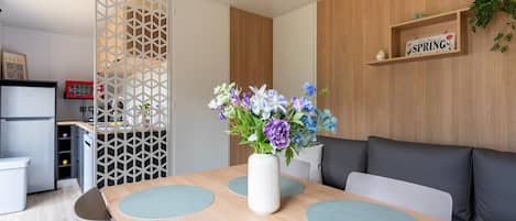 A modern living space with a dining area, kitchen, and a sofa.