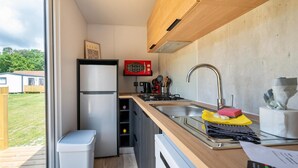 A compact kitchen with a built-in microwave, a sink, and a stove.