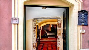 A building entrance with a stone staircase leading to an interior with a red carpet and a staircase. - Guest house Cà du Sciu Megu (Civezza)