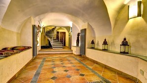 A hallway with a tiled floor, a staircase, and wall-mounted lanterns. - Guest house Cà du Sciu Megu (Civezza)