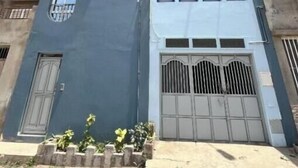 A multi-story building with a garage door, large windows, and a flat roof. - Dorade Double Room – Cozy Stay at Alto do Fortim B&B (Mindelo)