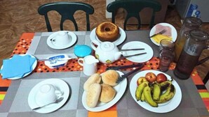 A dining table with plates of food, a teapot, and a jug. - Dorade Double Room – Cozy Stay at Alto do Fortim B&B (Mindelo)