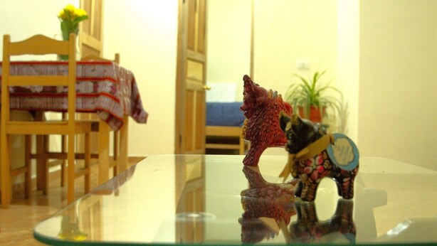 A glass table with a figurine of a wolf and a bear. - LA CASA DE VIDA (Cusco)