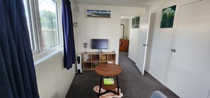 A narrow hallway with a window, a television, a small table, and a wardrobe. - The Nest - Dive in to Lloyd Elsmore Park for infinite opportunities (Manukau City)