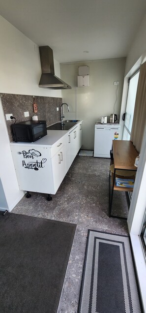 A compact kitchen with a microwave, toaster, and coffee maker. - The Nest - Dive in to Lloyd Elsmore Park for infinite opportunities (Manukau City)