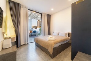 Ein modernes Hotelzimmer mit einem großen Bett, einem Schreibtisch und Blick auf die Stadt.