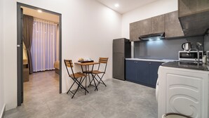 Una cocina compacta con comedor, refrigerador, microondas y lavamanos.