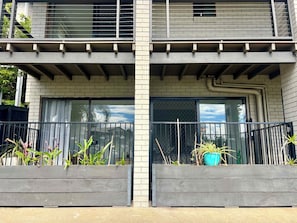 Ein zweistöckiges Gebäude mit Balkon, einem Fenstergitter und einem Blumentopf auf dem Balkon.