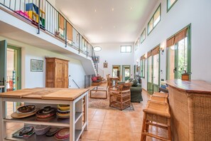 Ein geräumiges Loft mit hohen Decken, einem Essbereich, einer Sitzecke und einer Treppe, die zu einer erhöhten Ebene führt.