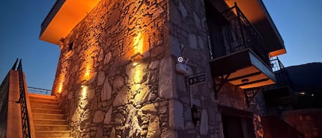 A stone building with a staircase leading to a balcony.