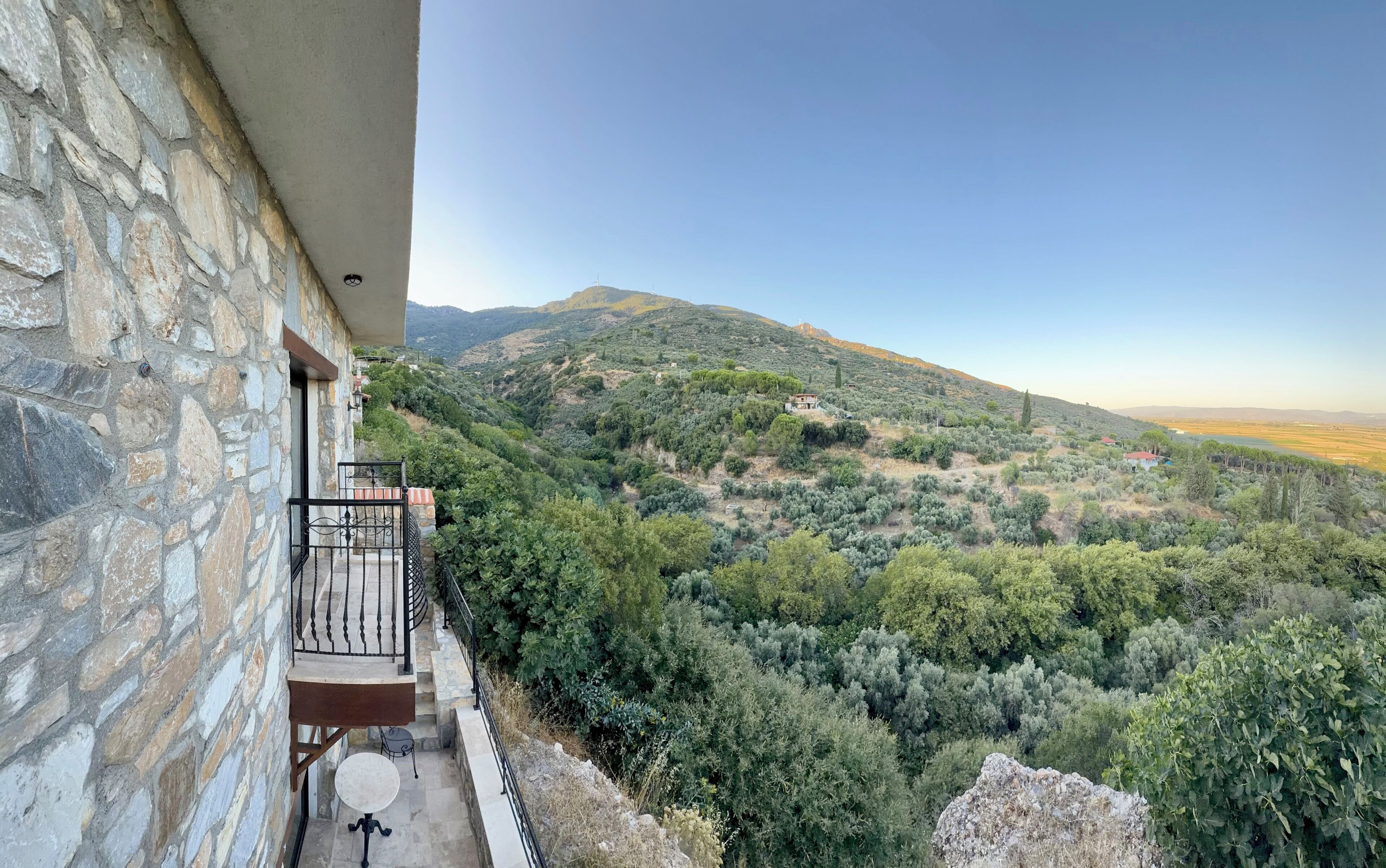 Un edificio de piedra con un balcón que da a un paisaje montañoso.