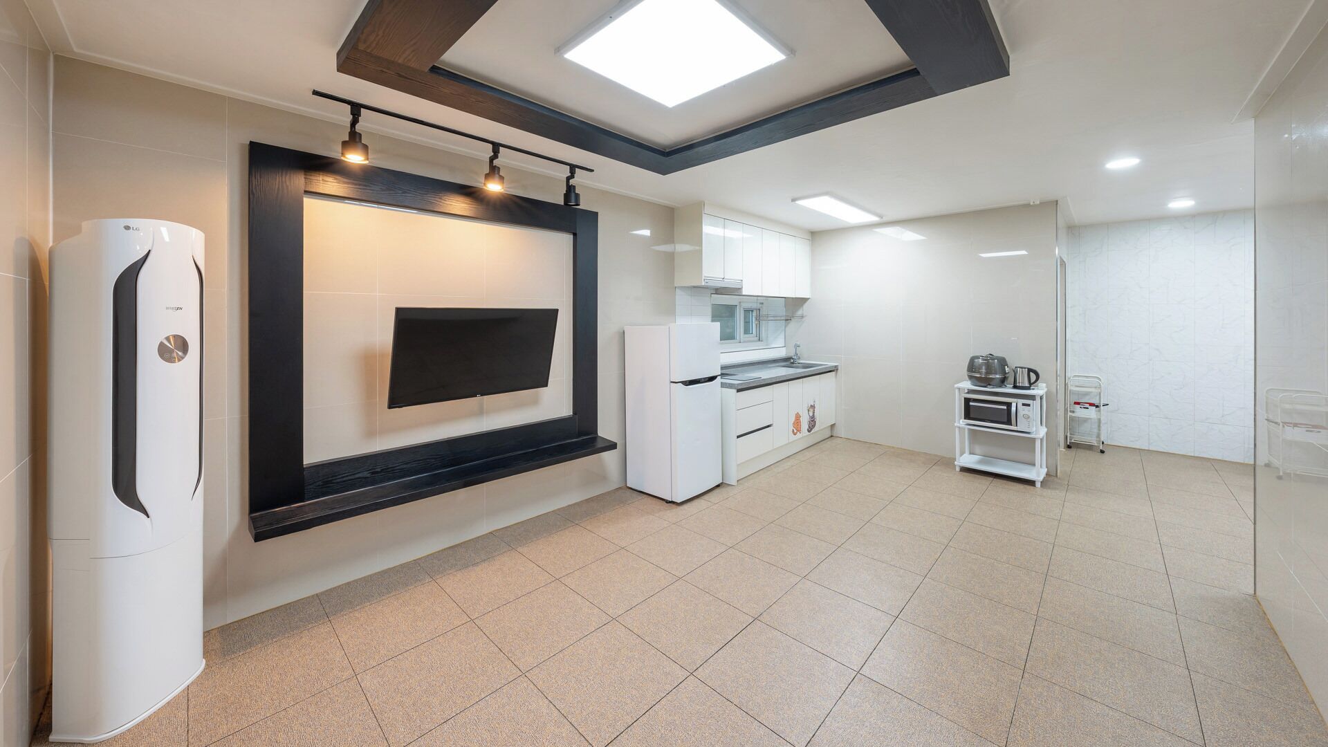 Cozinha moderna com televisão de tela plana, eletrodomésticos embutidos e piso de azulejo.