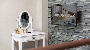 A bathroom vanity with a mirror, toiletries, and a teddy bear.