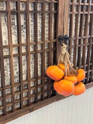 A wooden lattice wall with hanging orange fruits.