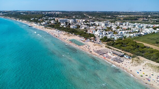An aerial view of a coastal area with a beach, buildings, and a clear blue sea. - 'Corso Roma Home Gallipoli' Apartment with Air Conditioning (Gallipoli)