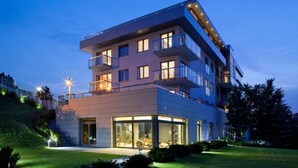 A multi-story building with balconies, large windows, and a well-lit entrance. - Sea Premium Aparthotel (Gdynia)