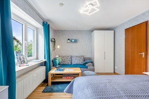 A modern bedroom with a bed, a sofa, a coffee table, and a wardrobe.