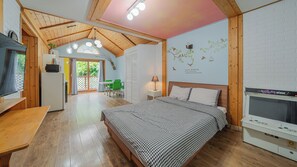 Un dormitorio acogedor con cama, televisión y kitchenette.
