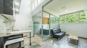 A modern bathroom with a glass shower enclosure, a bathtub, and a seating area. - Gapyeong Funny Mongmong Galaxy House (Gapyeong)