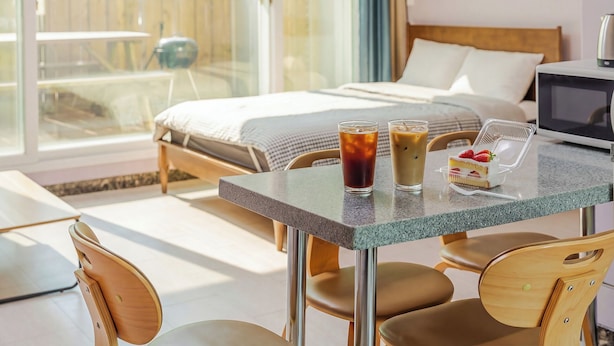 Ein Hotelzimmer mit einem Bett, einem Tisch mit Getränken und einer Nachspeise sowie einem Fernseher.