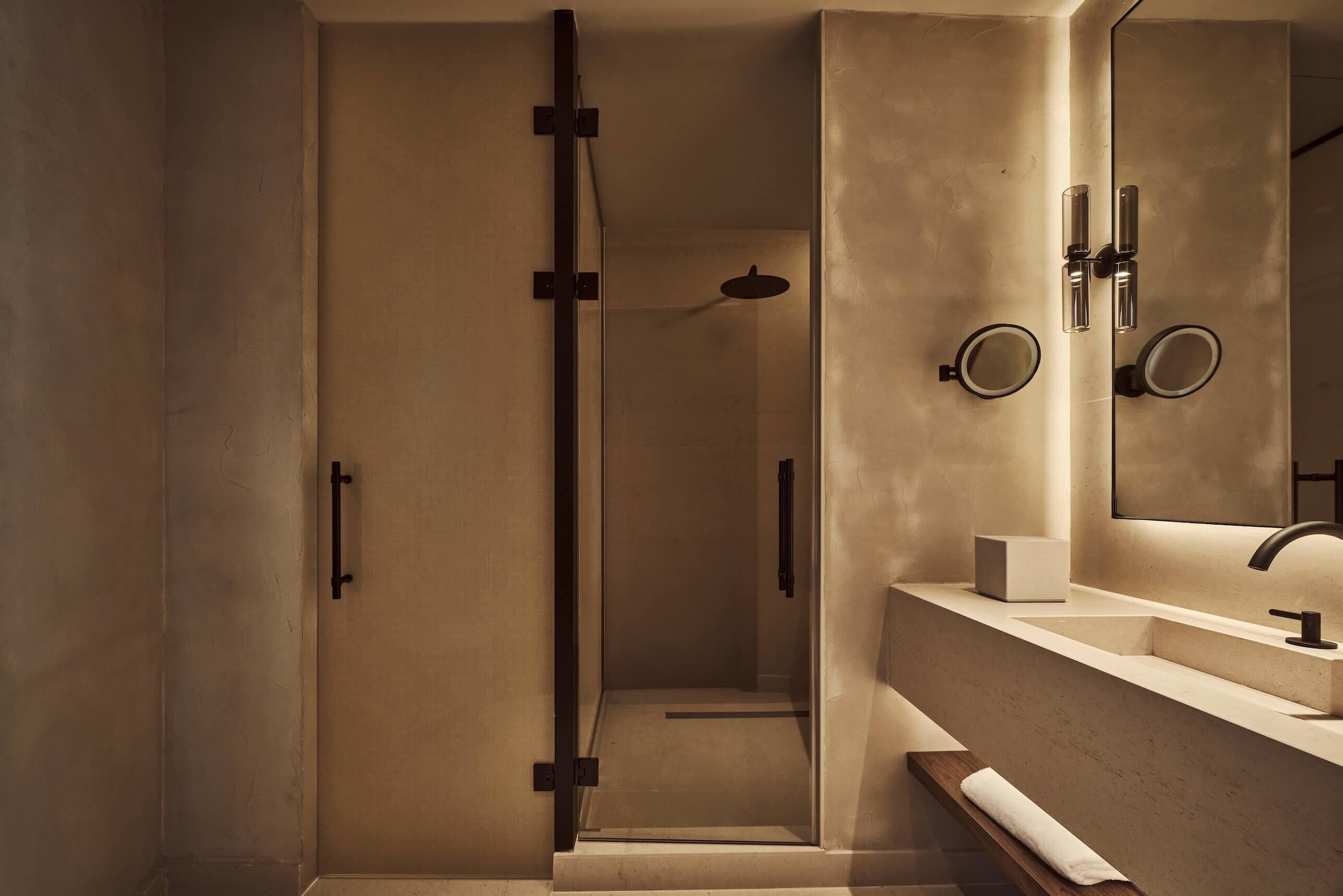 A modern bathroom with a glass shower enclosure, a vanity with a mirror, and a towel rack.