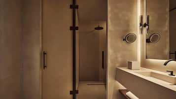 A modern bathroom with a glass shower enclosure, a vanity with a mirror, and a towel rack.