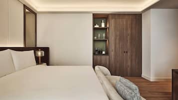 A modern bedroom with a bed, bedside table, lamp, built-in shelves, and a wardrobe.