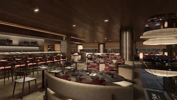 A spacious restaurant with multiple dining areas, including a central seating area with round tables and red chairs, and a bar area with high stools.