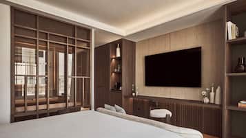 A modern bedroom with a large bed, a TV mounted on the wall, and built-in shelving.