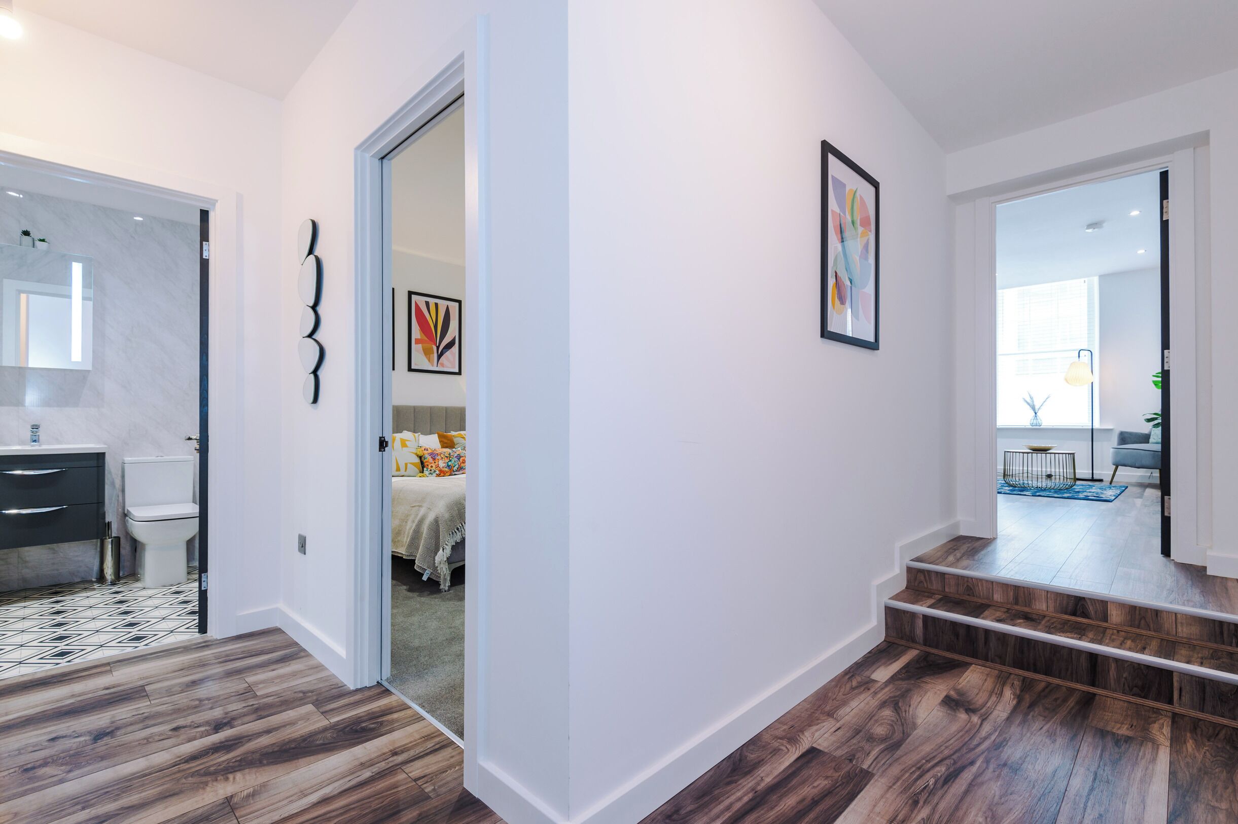 A modern interior with a bathroom, a staircase, and a living area.
