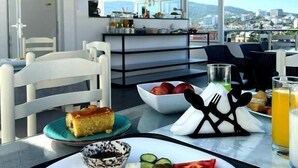 Un comedor con una mesa preparada para el desayuno, que incluye un plato con comida, un bol y un vaso de jugo de naranja.