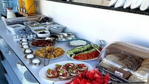 Un bufé con diversos alimentos y utensilios.