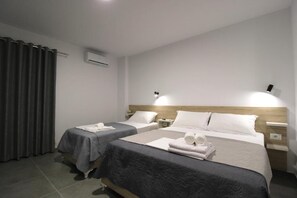 Habitación cuádruple Deluxe, balcón, vista a la ciudad | Caja de seguridad en la habitación, escritorio y insonorización 