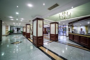 A hotel lobby with a reception desk, a chandelier, and a clean, tiled floor. - Helena Park Hotel (Nessebar)