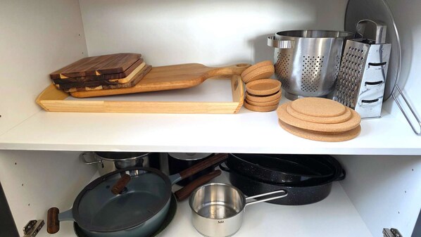 Una cucina con un tagliere di legno, una grattugia e sottobicchieri in sughero.