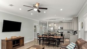 Una sala moderna con comedor, cocina y ventilador de techo.