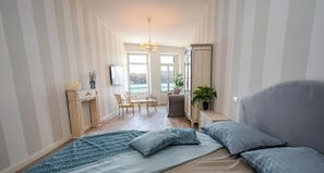 A bedroom with a bed, a desk, a chair, a potted plant, and a view through a window. - Romantic Benaco Salò (Salò)