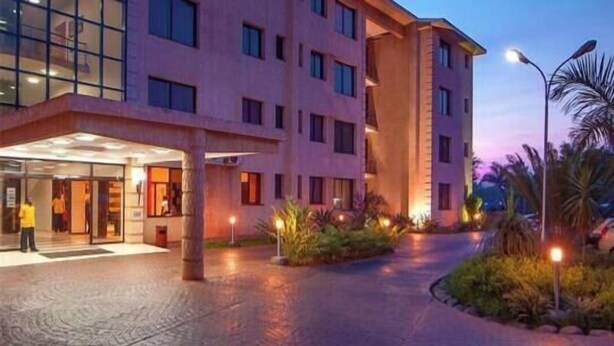A hotel entrance with a paved walkway, glass doors, and a building with multiple floors and windows. - Hotel 33 Kampala (Kampala)