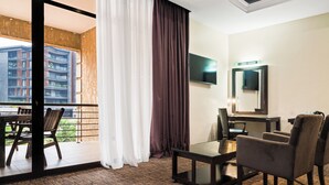 A hotel room with a balcony, a TV, a desk, and a chair. - Hotel 33 Kampala (Kampala)