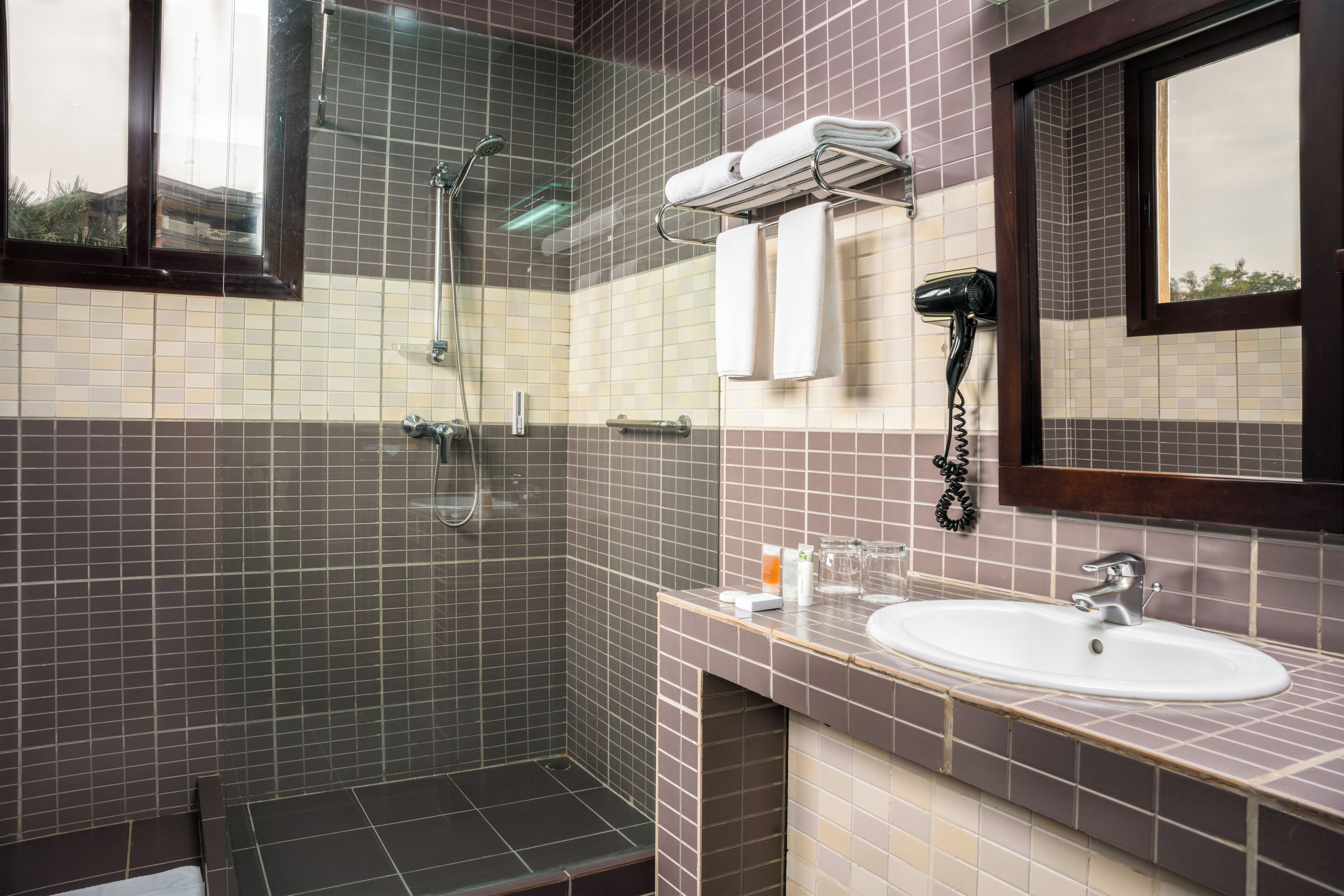 Une salle de bain avec une douche, un lavabo et un miroir.
