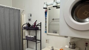 Een badkamer met toilet, wastafel en wasmachine.