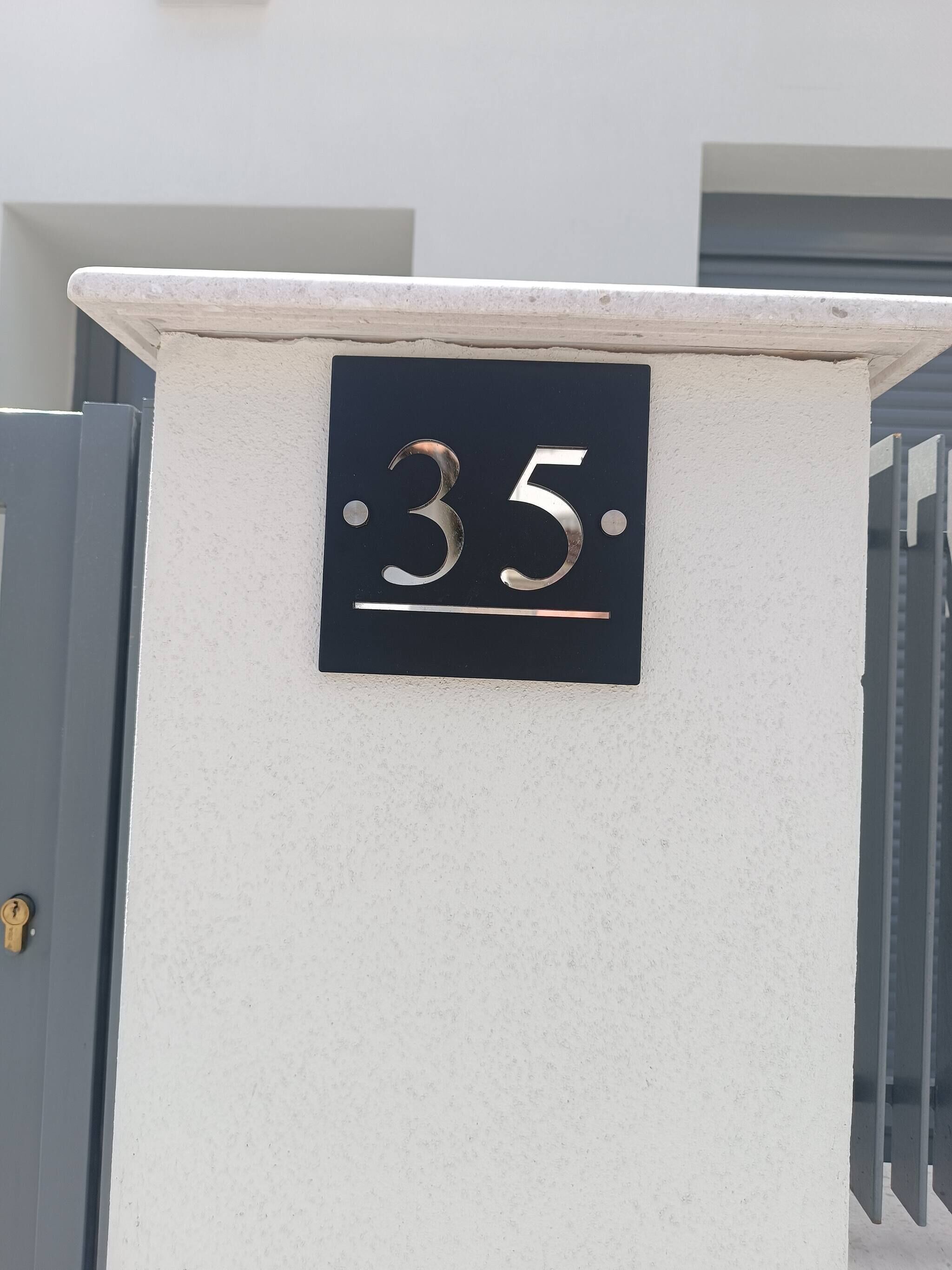 Eine Hausnummer an einer weißen Wand.