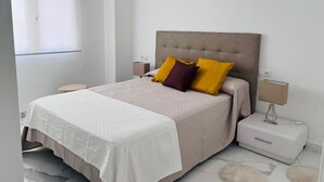 Un dormitorio moderno con cama, mesitas de noche y una ventana.